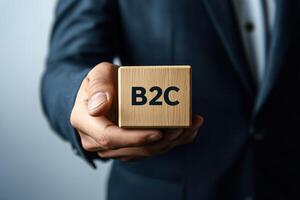 Closeup of a hand holding a wooden block displaying the term 'B2C' photo