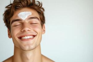 Smiling person with skincare cream applied on forehead photo