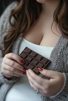 Close-up of a person holding a bar of chocolate in their hands photo