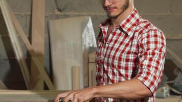 Skilled carpenter grinding wood with precision in a vibrant workshop video