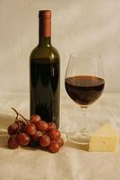 Elegant Pairing of Red Wine, Grapes, and Cheese on a Beige Tablecloth photo