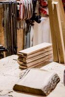 Woodworking tools and neatly stacked lumber in a rustic workshop during daylight photo