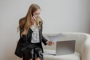 Professional woman working on business documents while on the phone in a modern office environment photo