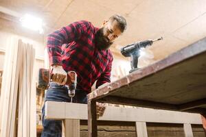 Skilled carpenter constructs wooden furniture in workshop using power tools during daytime hours photo
