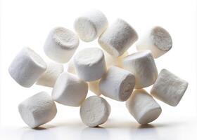 Fluffy marshmallows scattered on a white surface. photo