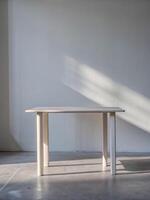 Minimalist white table casting a shadow on the wall. photo