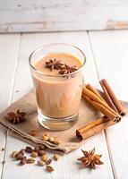 Spiced chai latte garnished with star anise and cinnamon sticks. photo