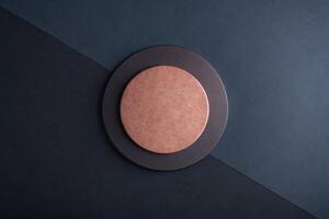 Copper-colored circle on a dark geometric background. photo