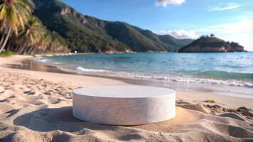 Round stone platform resting on the sandy beach with mountains in the distance. photo