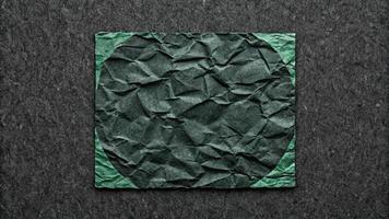 Crumpled green paper framed on a dark background. photo