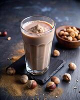 Creamy coffee topped with foam beside scattered nuts. photo