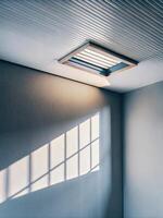 Sunlight streaming through a modern ceiling vent. photo