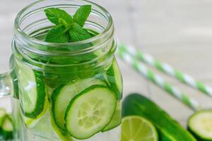 Cucumber Mint Water in Glass Jar with Striped Straw photo