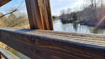 Wooden Railing Overlooking Calm River Scene photo
