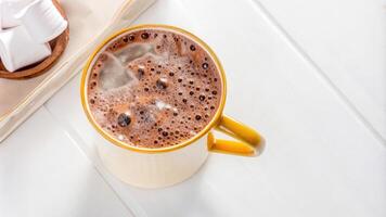 Hot Chocolate in a Yellow Mug on White Table photo