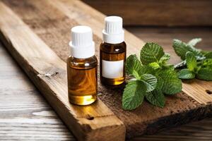 Essential Oil Bottles with Fresh Mint Leaves photo