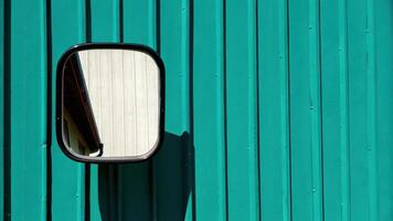 Teal Metal Wall Reflecting a Side Mirror Accent photo