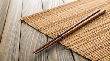 Wooden Chopsticks on Bamboo Sushi Mat photo
