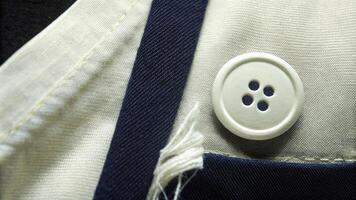Close-Up of White Button on Blue and White Fabric with Fine Details photo