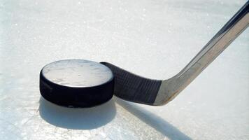 Hockey Stick and Puck on Ice Rink Surface Closeup photo