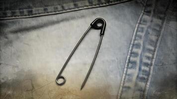 Black Safety Pin on Denim Fabric Close-Up photo