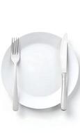 An empty plate with a knife and fork on it photo