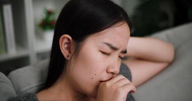 Handheld selective focus shot, Stressed young woman sits alone on a sofa, thinking aimlessly, feeling worried about something. Life problems video