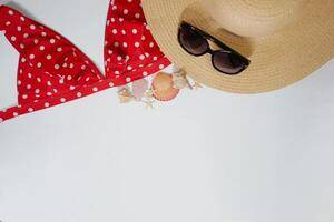 Summer travel vacation mood layout lifestyle spa wellness concept with accessories and copy space. Top view flat lay background, including straw hat, sunglasses, swimsuit, seashells and pebbles photo