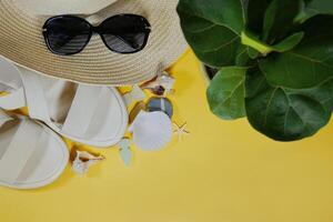 Summer travel mood layout lifestyle spa wellness concept with beach accessories and copy space. Top view flat lay background, including straw hat, sunglasses, sandals, seashells and pebbles photo