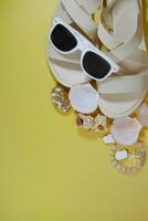 Summer travel vacation mood layout lifestyle spa concept with beach accessories and copy space. Top view flat lay background, including sunglasses, sandals, seashells and pebbles photo