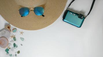 Summer travel vacation mood layout lifestyle spa or wellness concept with beach accessories and copy space. Top view flat lay background, including straw hat, sunglasses, photo camera