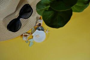 Summer travel vacation mood layout lifestyle spa wellness concept with beach accessories and copy space. Top view flat lay background, including straw hat, sunglasses, seashells and pebbles photo