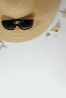 Summer travel mood layout lifestyle spa or wellness concept with beach accessories and copy space. Top view flat lay background, including straw hat, sunglasses, seashells and pebbles photo