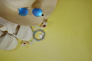 Summer travel vacation mood layout lifestyle spa wellness concept with beach accessories and copy space. Top view flat lay background, including straw hat, sunglasses, sandals, seashells photo