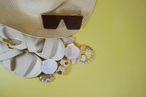 Summer travel vacation mood layout lifestyle wellness concept with beach accessories and copy space. Top view flat lay background, including straw hat, sunglasses, sandals, seashells and pebbles photo