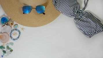 Summer travel layout lifestyle spa wellness concept with beach accessories and copy space. Top view flat lay background, including straw hat, sunglasses, swimsuit, seashells and pebbles photo