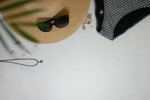 Summer travel vacation layout lifestyle spa wellness concept with beach accessories and copy space. Top view flat lay background, including straw hat, sunglasses, swimsuit, seashells and pebbles photo