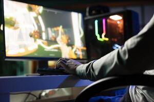 Guy playing first person shooter videogame with automatic gun shooting laser bullets at flying robotic foes. Close up of gamer competing in PvP online multiplayer game tourney against opponents photo