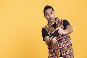Man having surprised look on face after being defeated while playing videogames on smartphone. Person having shocked facial expression after being beaten by other players, studio background photo