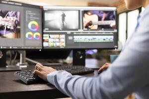 Closeup of editor with hand on keyboard, using advanced software to refine movie footage. Professional filmmaker working with multi monitor, adjusting film frames to improve cinematic quality. photo