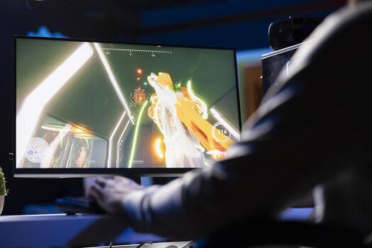 Man playing SF FPS videogame, having fun in dark apartment room, using gaming computer peripherals. Gamer competing in PvP internet multiplayer game, fighting enemies with futuristic gun, close up photo