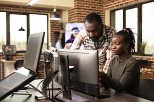 grave africano americano colegas analizando un puesta en marcha proyecto en un escritorio monitor en un puesta en marcha compañía. determinado negro creativo profesionales trabajando juntos a computadora, refinando diseños foto