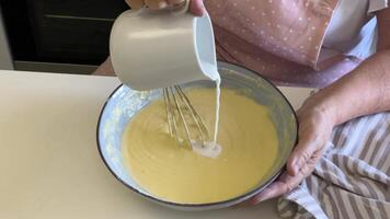 Baker adding milk and ingredients in a bowl video