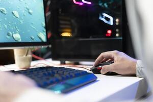 Person in neon lit apartment playing singleplayer videogame with spaceship shooting laser bullets at asteroids. Close up of gamer using crosshair overlay to hit targets in science fiction arcade game photo