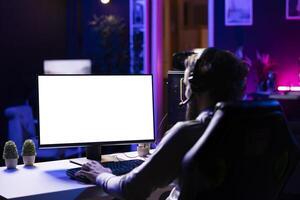 Player having fun by using isolated screen computer display to play singleplayer videogame. Professional gamer using mockup PC desktop to complete levels in game, talking with friends photo