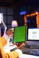 Freelancer taking break from checking stock exchange to watch videos on isolated screen tablet. Stockholder working from home using mockup device and looking at market shares growth photo