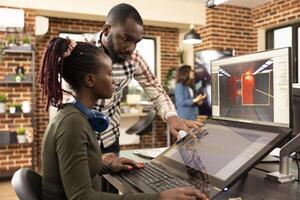 Creative team of black man and woman brainstorming together in modern workspace, collaborating on graphic design projects. African american coworkers utilizing modern technology for multimedia work. photo