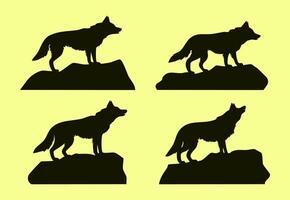 Silhouette of a wolf standing on a rock collection vector