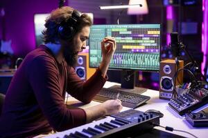 Composer songwriter taking notes to create a new song in his home studio, writing down lyrics and musical notes before recording his tune on mixing console and microphone, music industry. photo