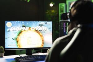 Gamer receiving game over screen, getting his spaceship destroyed in huge explosion while flying in galaxy, killed by enemies. Man losing science fiction spacecraft videogame level photo